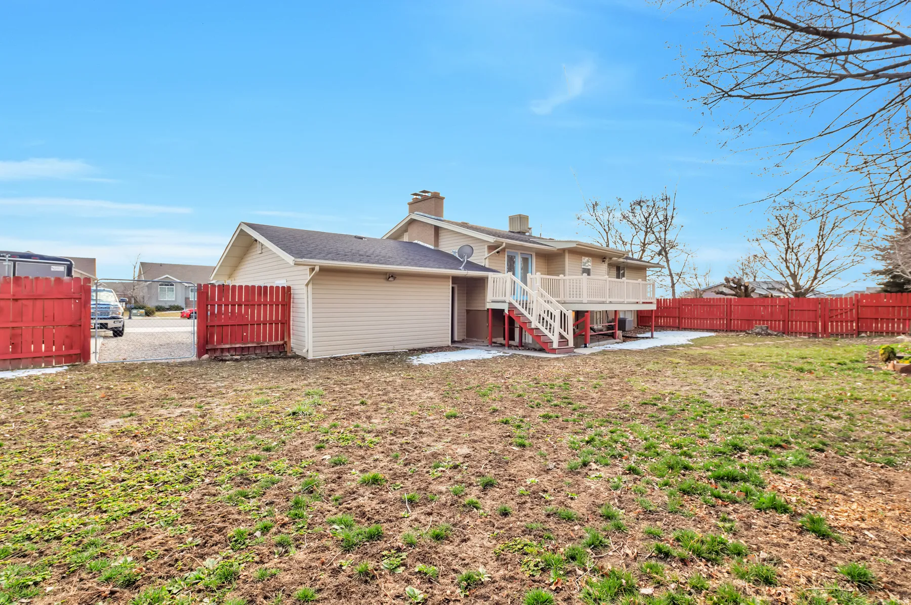Back of house featuring a chimney, a fenced backyard, a wooden deck, and a patio