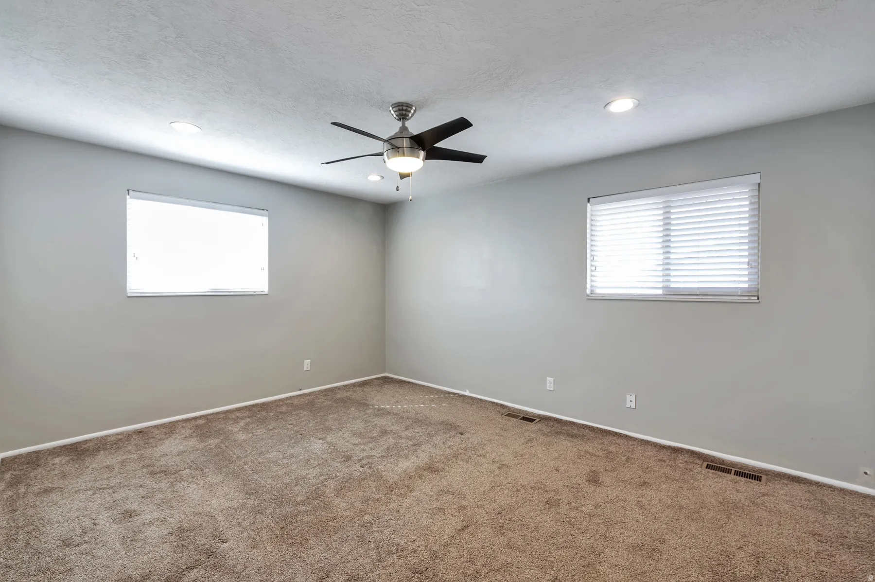 Unfurnished room with carpet floors, ceiling fan, healthy amount of natural light, and a textured ceiling