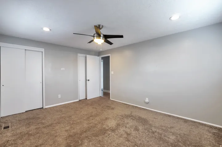 Unfurnished bedroom featuring two closets, carpet flooring, ceiling fan, and recessed lighting