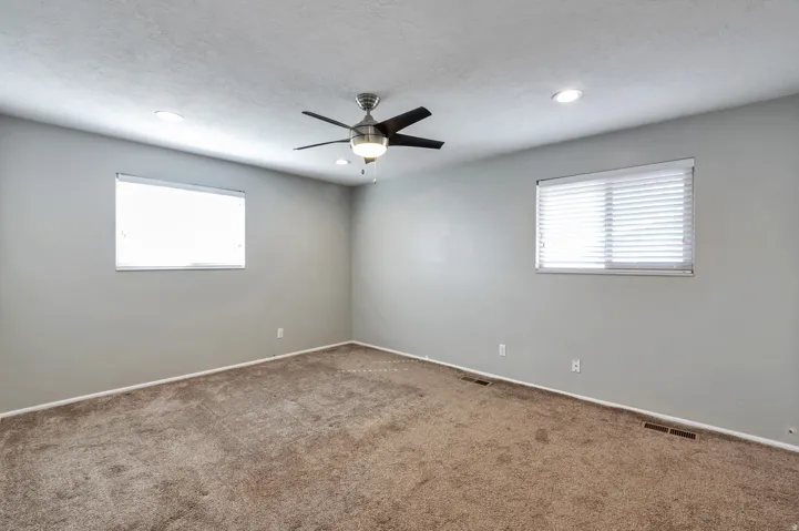Unfurnished room with carpet floors, ceiling fan, healthy amount of natural light, and a textured ceiling