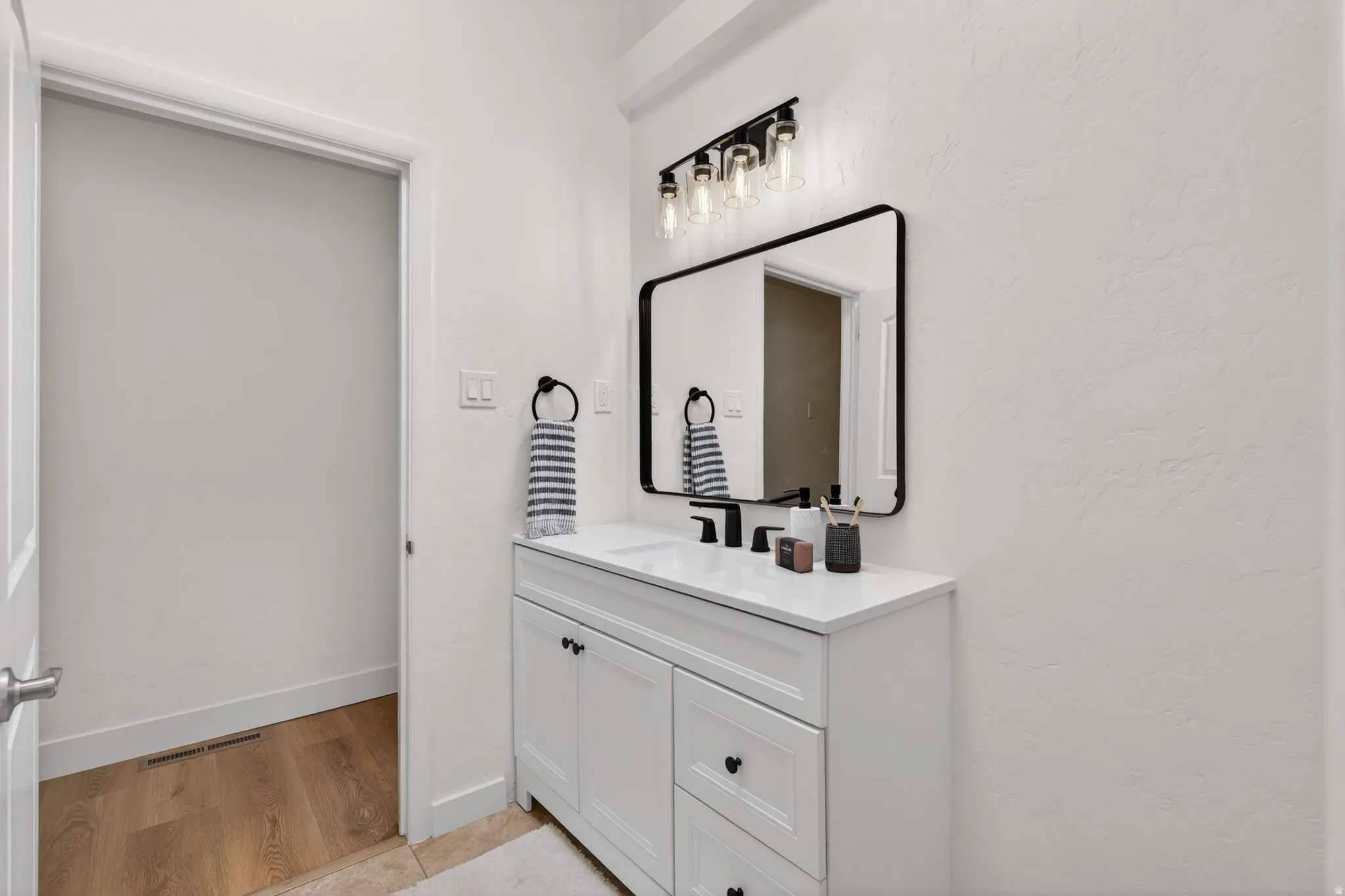 Refreshed bathroom featuring a modern vanity suite and light tile flooring. A bright space that’s ready for your personal touch.