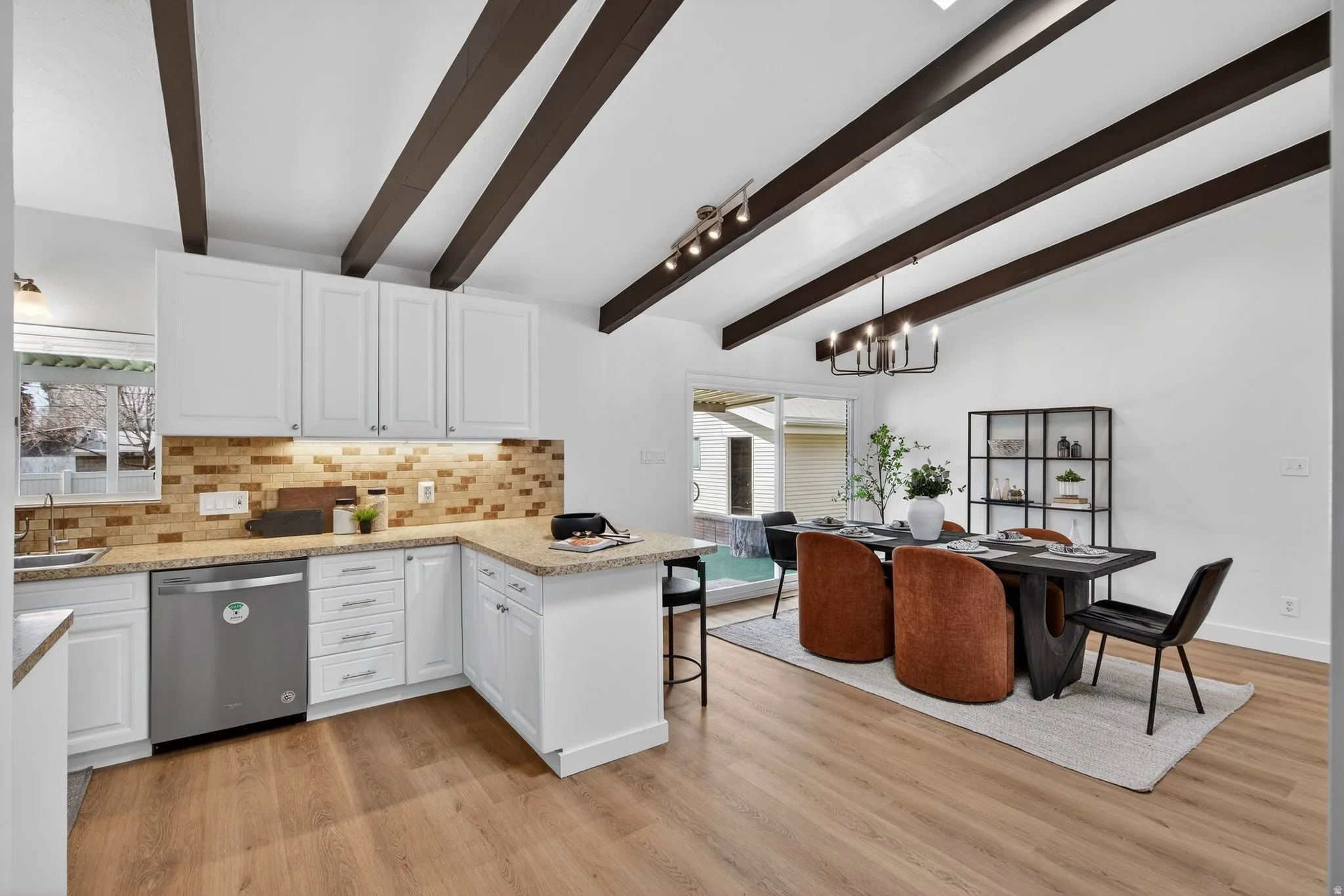 Cook and entertain in this bright kitchen featuring crisp white cabinetry and stainless steel finishes. The spacious peninsula doubles as a breakfast bar, making this a functional gathering spot.
