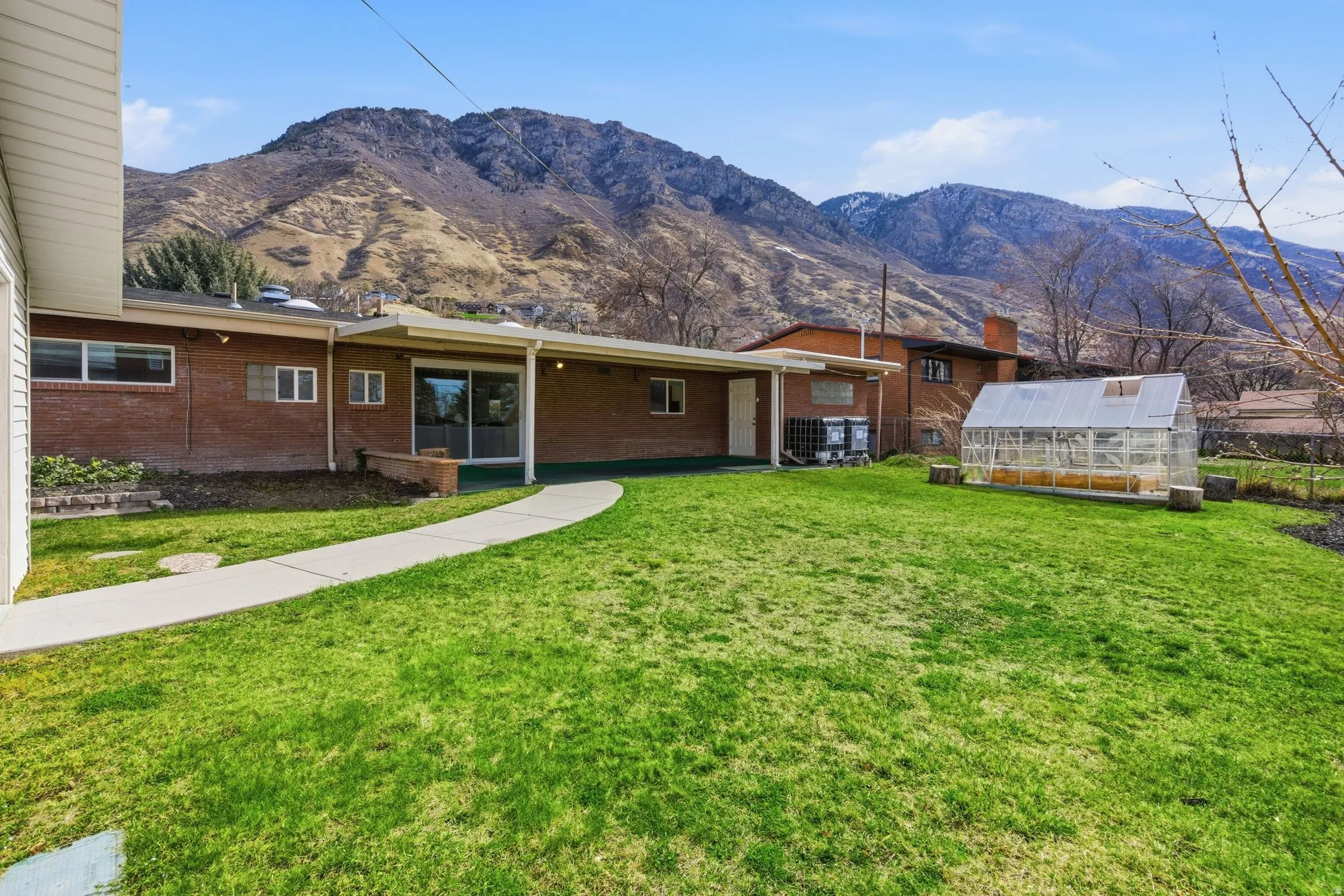 Stunning mountain views and an expansive covered patio define this backyard. An outdoor living space with plenty of room for play, gardening, and relaxation.