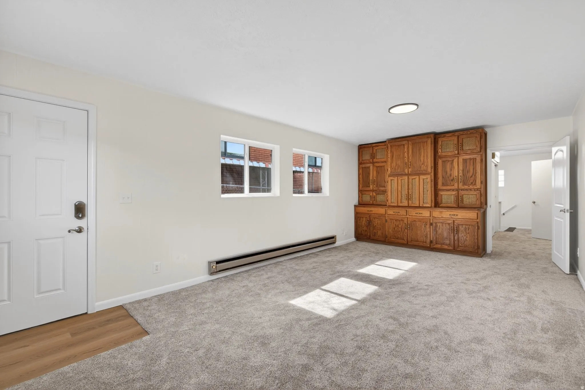 Flex-space featuring plenty of natural light, neutral carpeting, extra storage unit, baseboard heating, and a private entry. Possible ADU conversion, rental income, or a guest wing (buyer to verify city requirements).