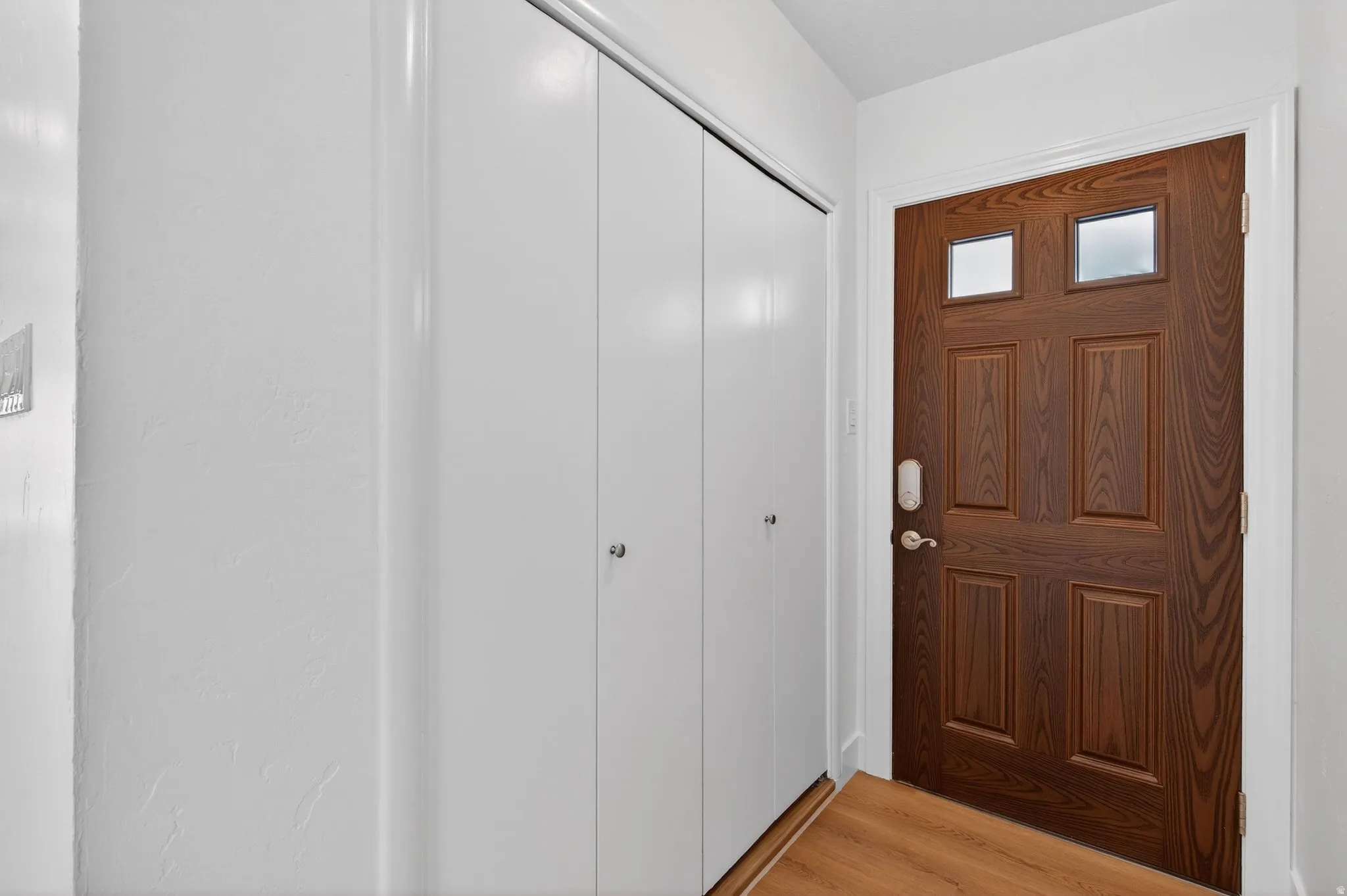 Entry foyer featuring durable wood-like planks and a clean, contemporary aesthetic.