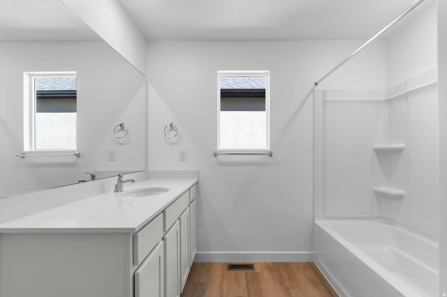 Full bath with vanity, light wood-style flooring, and bathtub / shower combination