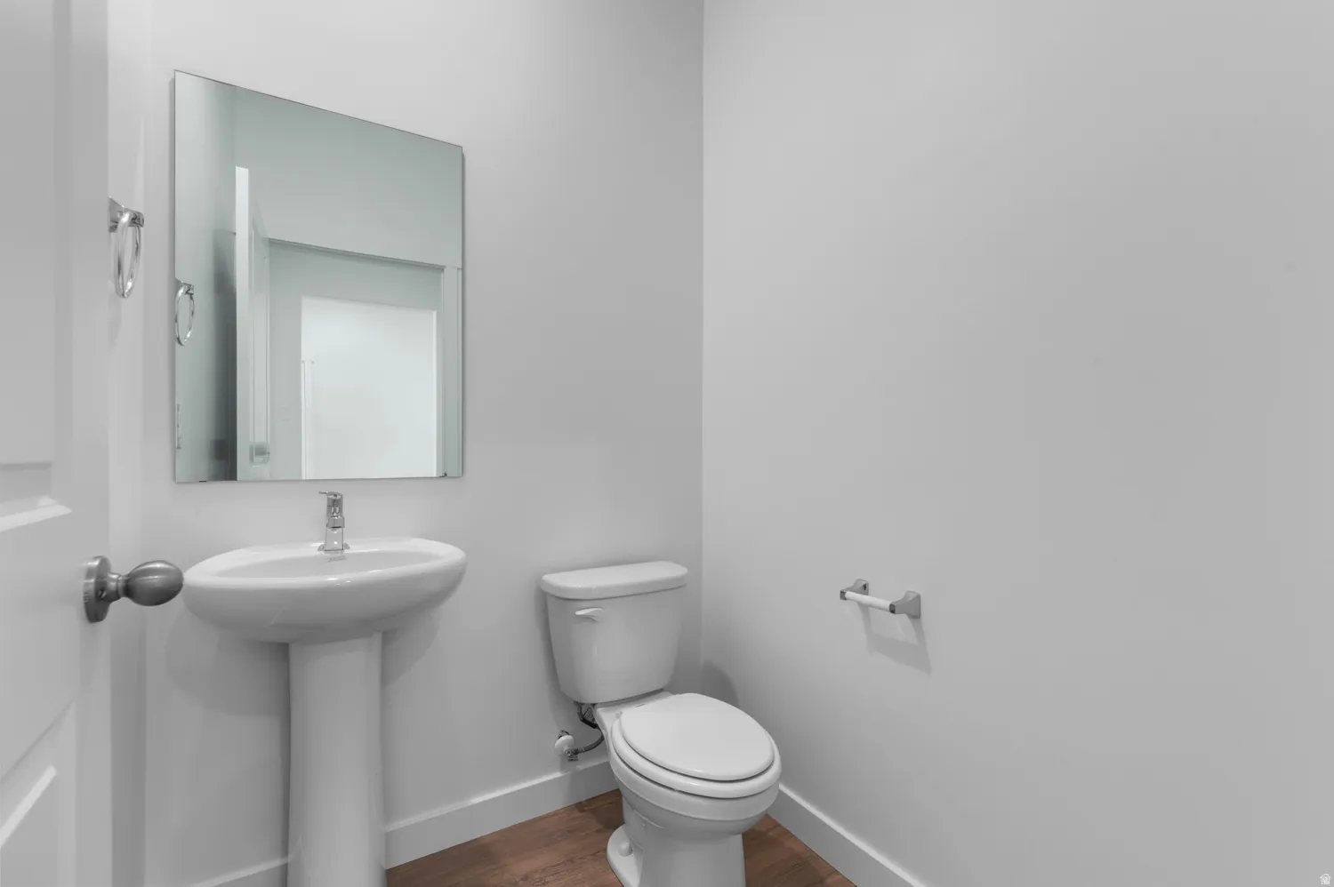 Half bath with toilet and dark wood finished floors