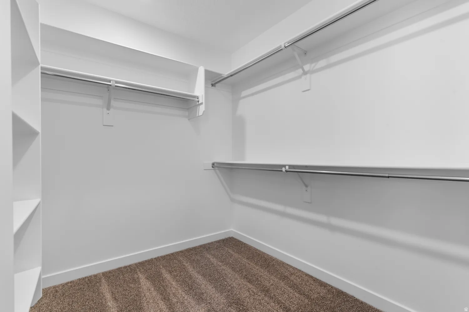 Walk in closet with dark colored carpet