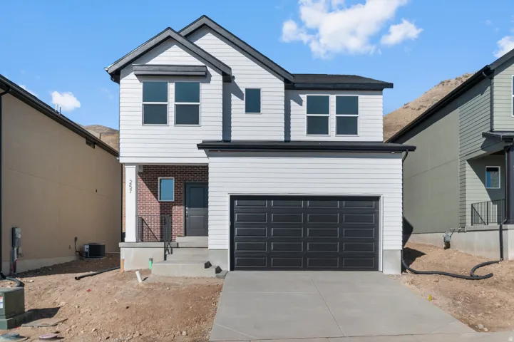 View of front of property with concrete driveway, brick siding, a garage, and a porch