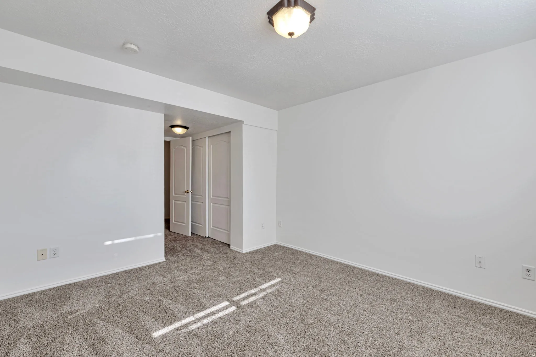 Carpeted spare room with baseboards and a textured ceiling