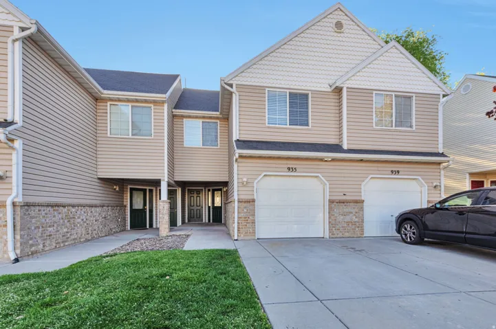 View of front facade with an attached garage, driveway, and a front lawn