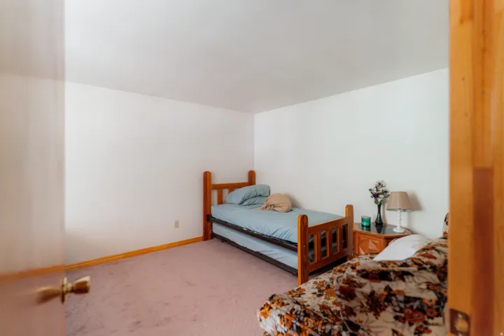 Bedroom with light colored carpet and baseboards