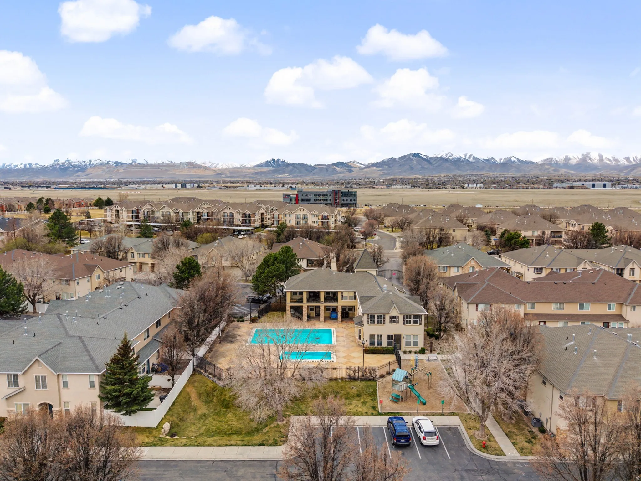 Aerial perspective of suburban area with a pool area and a mountain backdrop