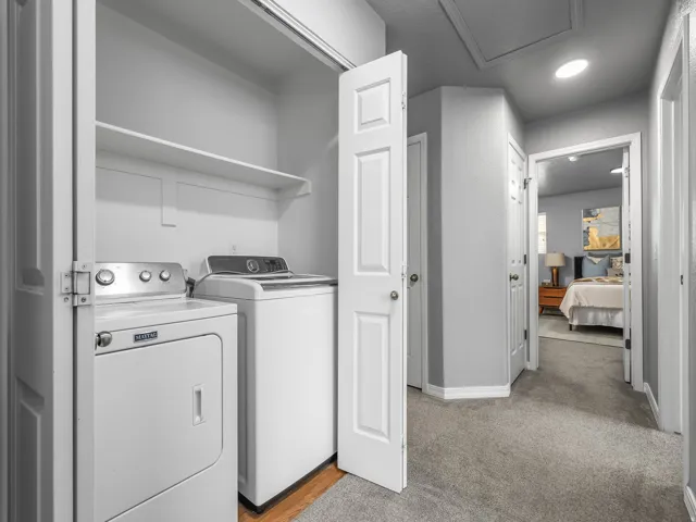 Laundry area featuring washer and dryer and light carpet