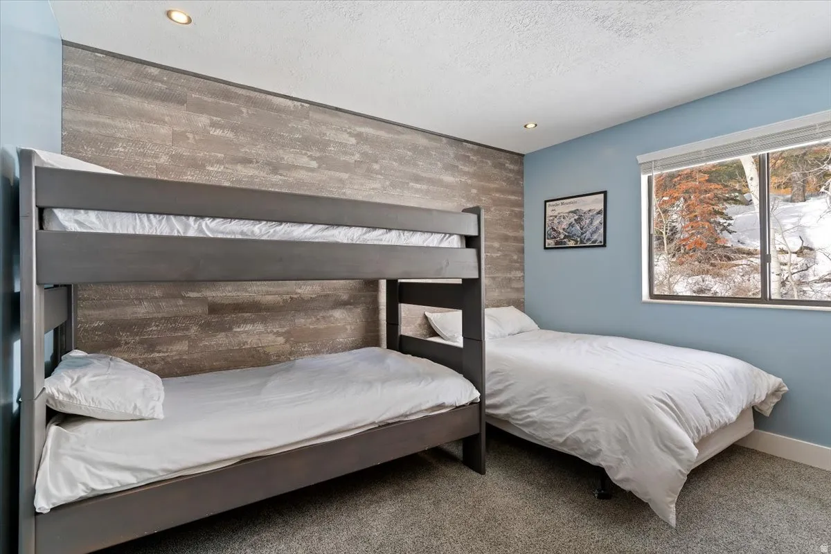 Bedroom featuring an accent wall, carpet, and recessed lighting