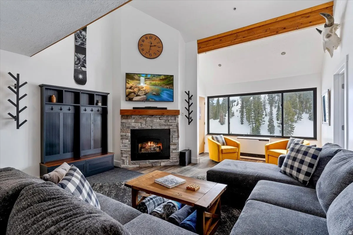 Living area featuring lofted ceiling, a fireplace, and wood finished floors