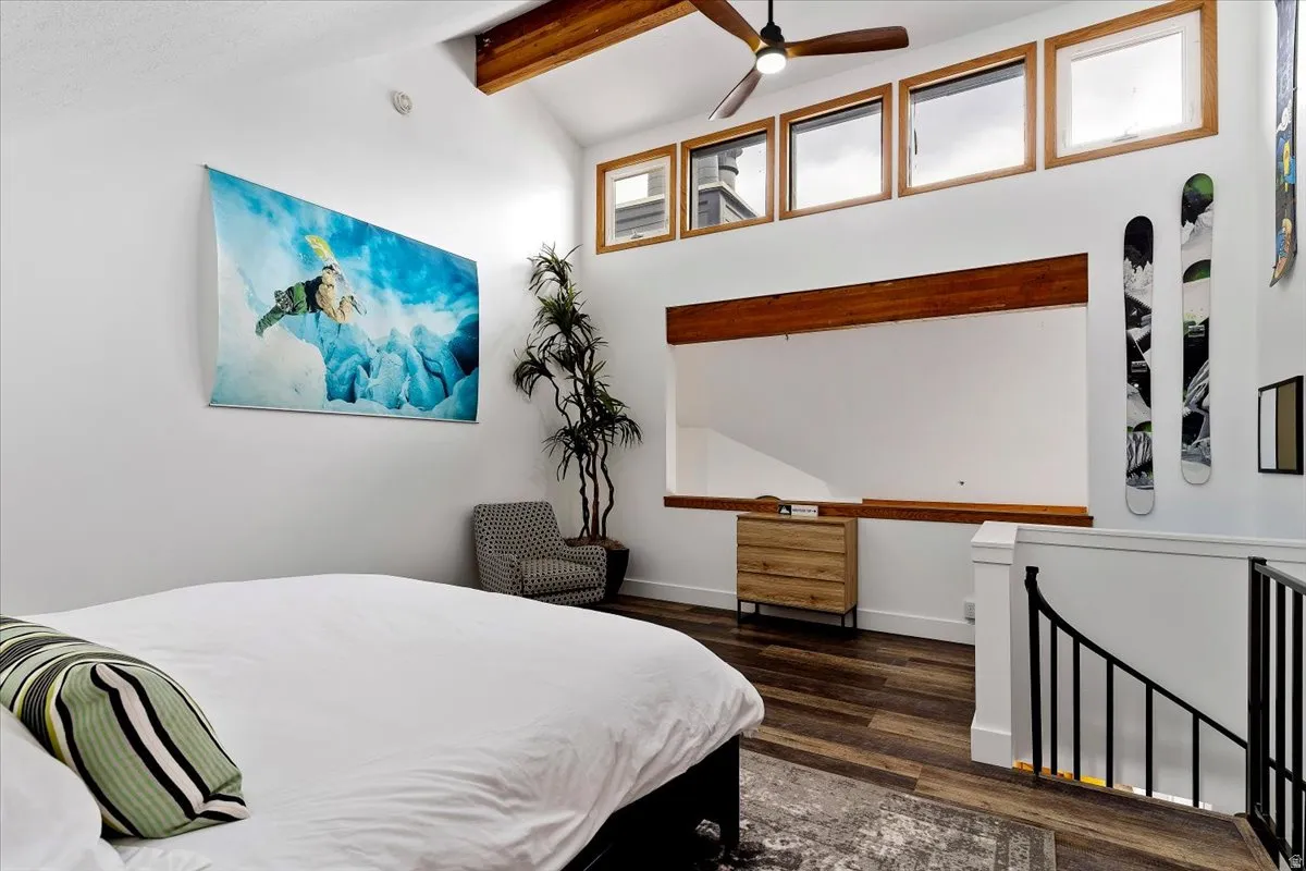 Bedroom with dark wood finished floors, vaulted ceiling, and a ceiling fan