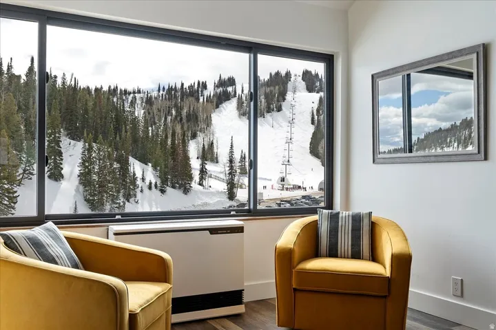Living area with wood finished floors and radiator heating unit