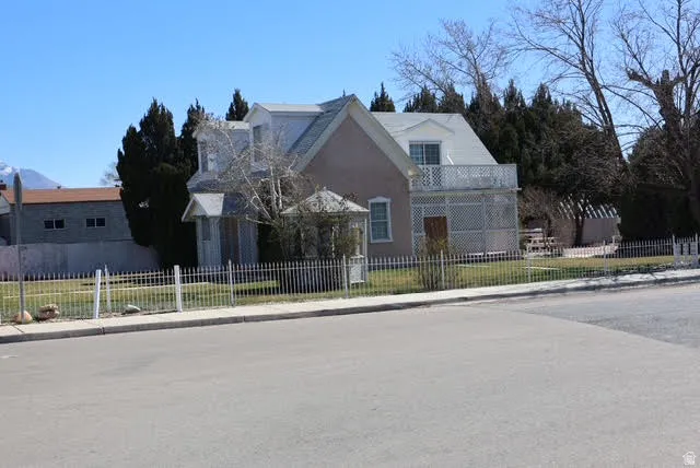 View of front of property featuring a fenced front yard, a balcony, and stucco siding