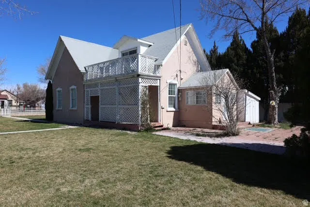 View of side of property with a yard and stucco siding