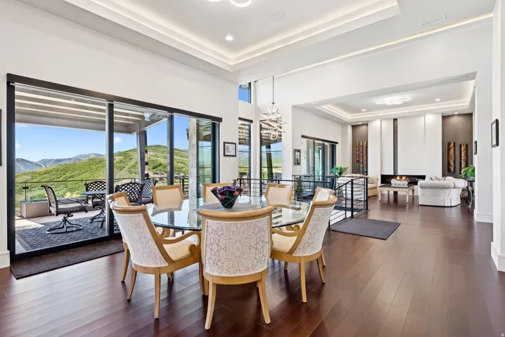 Dining room with a mountain view, dark wood finished floors, recessed lighting, and a tray ceiling