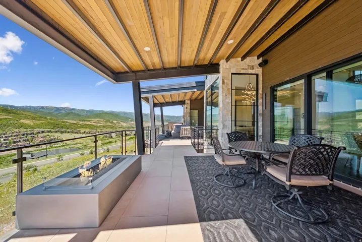 View of patio featuring an outdoor fire pit, outdoor dining area, and a mountain view