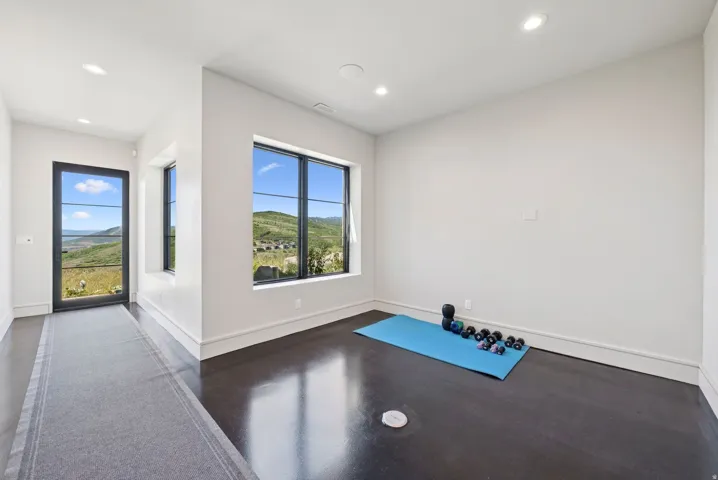 Exercise area featuring a mountain view, recessed lighting, and concrete floors