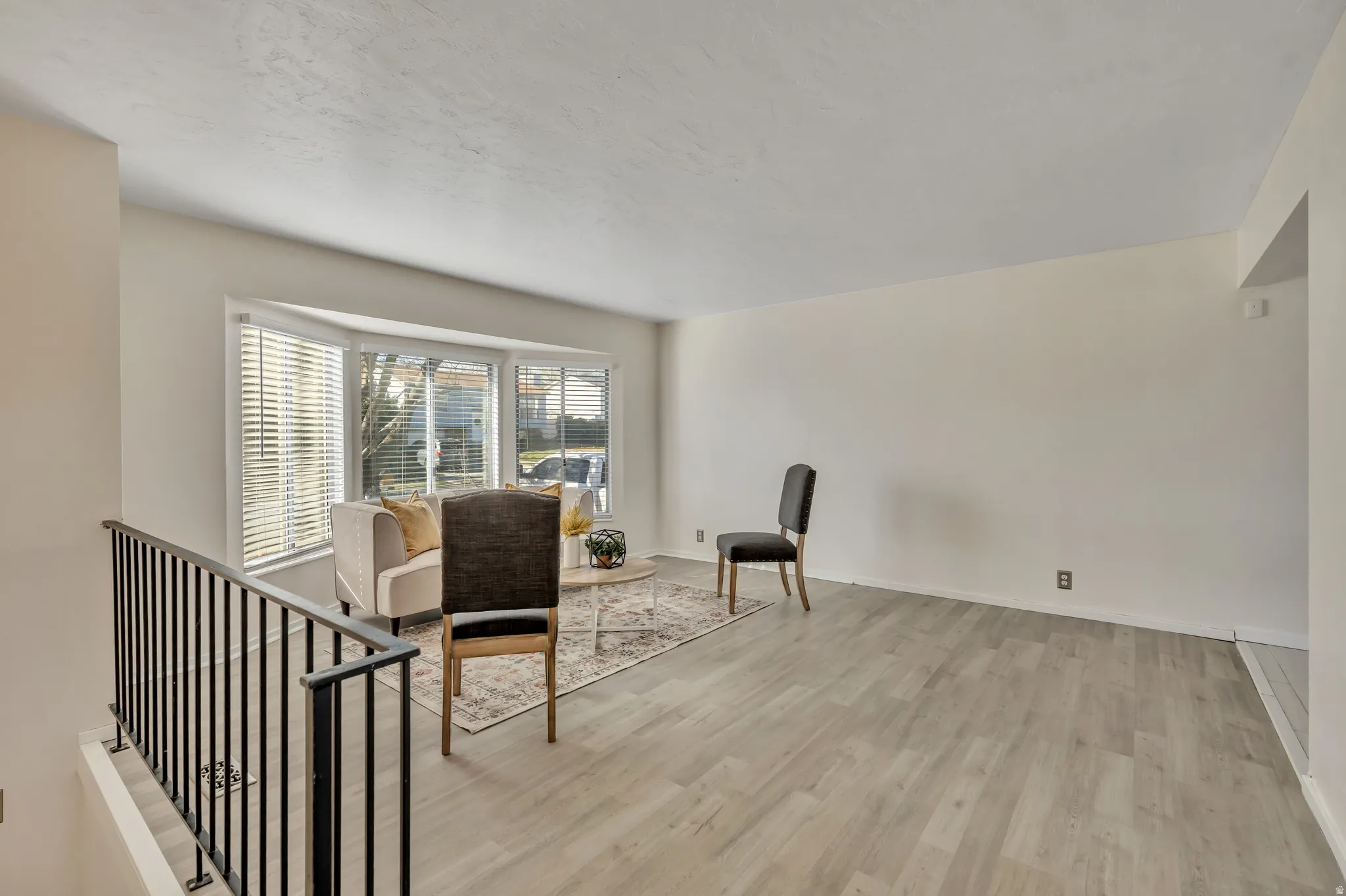 Living area featuring light wood-style flooring and an upstairs landing