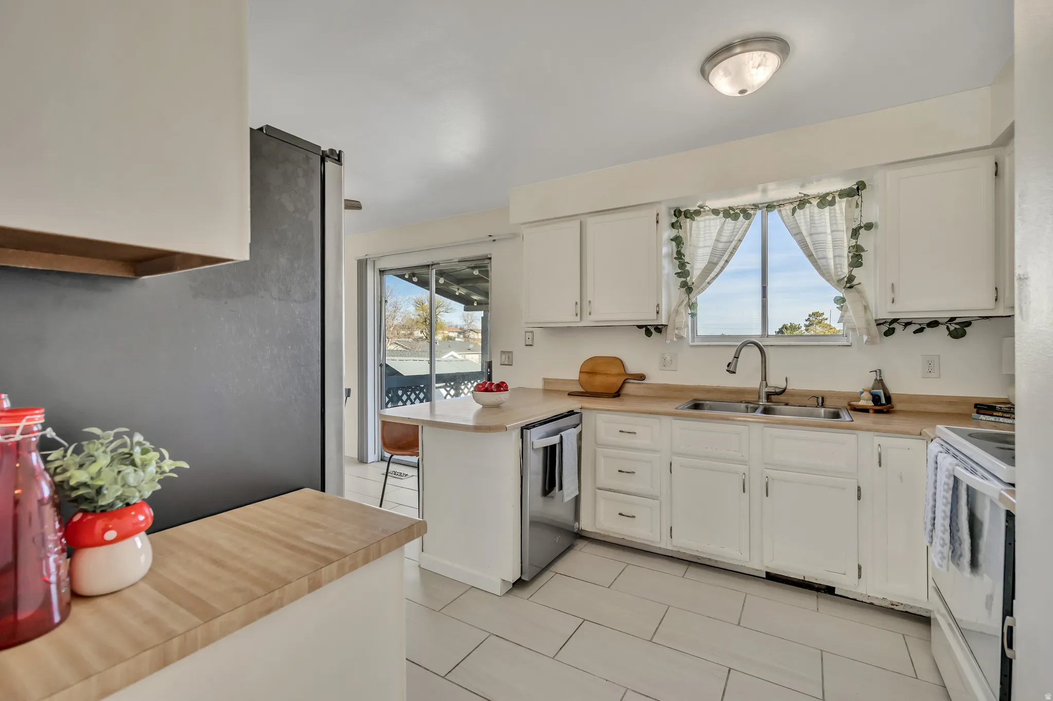Kitchen with light countertops, stainless steel appliances, and white cabinets