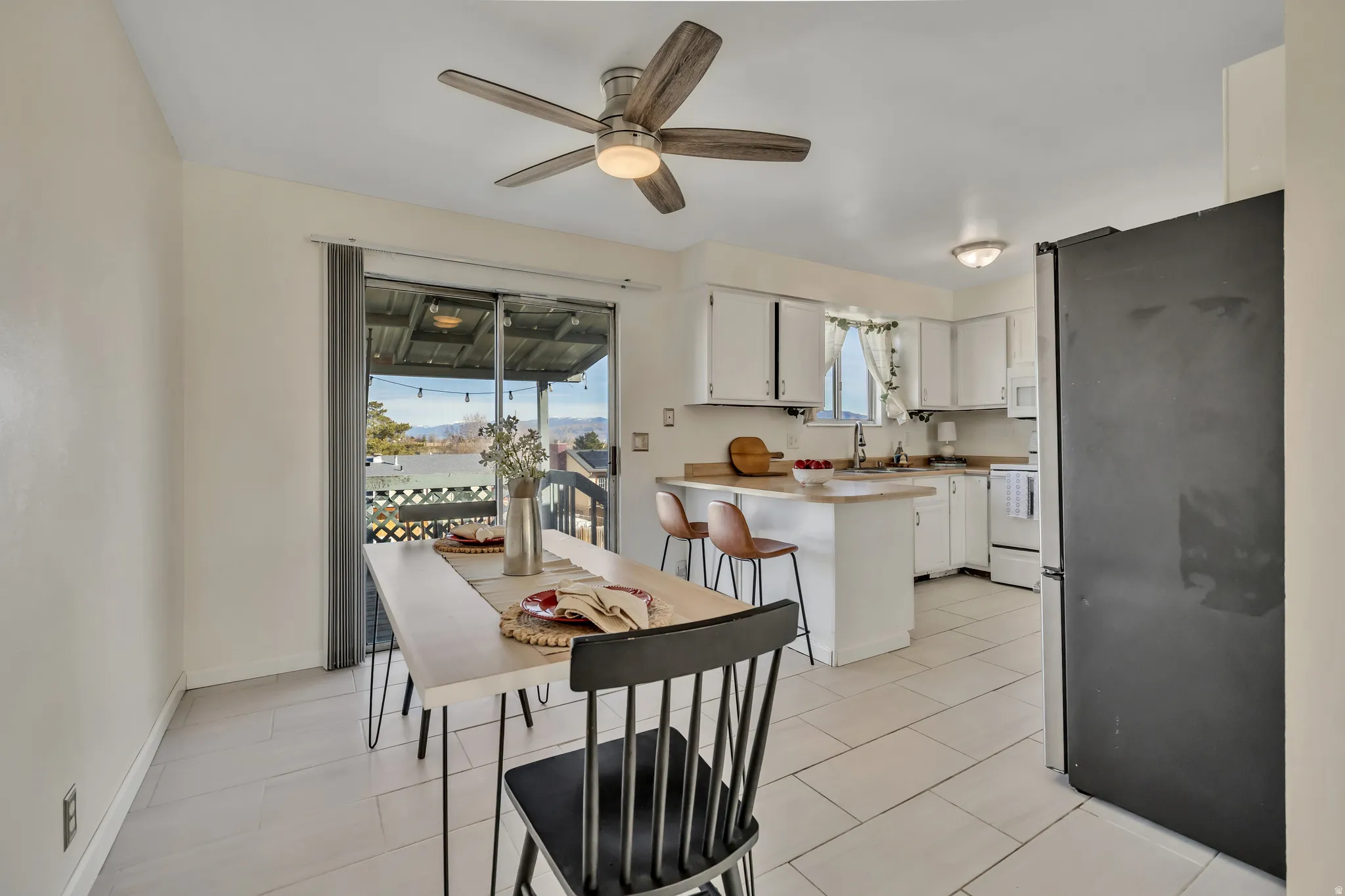 Dining room with a ceiling fan and light tile patterned floors