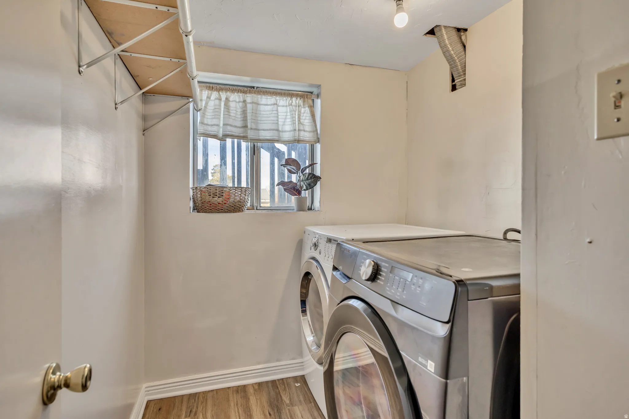 Laundry area featuring washing machine and clothes dryer and light wood-style floors