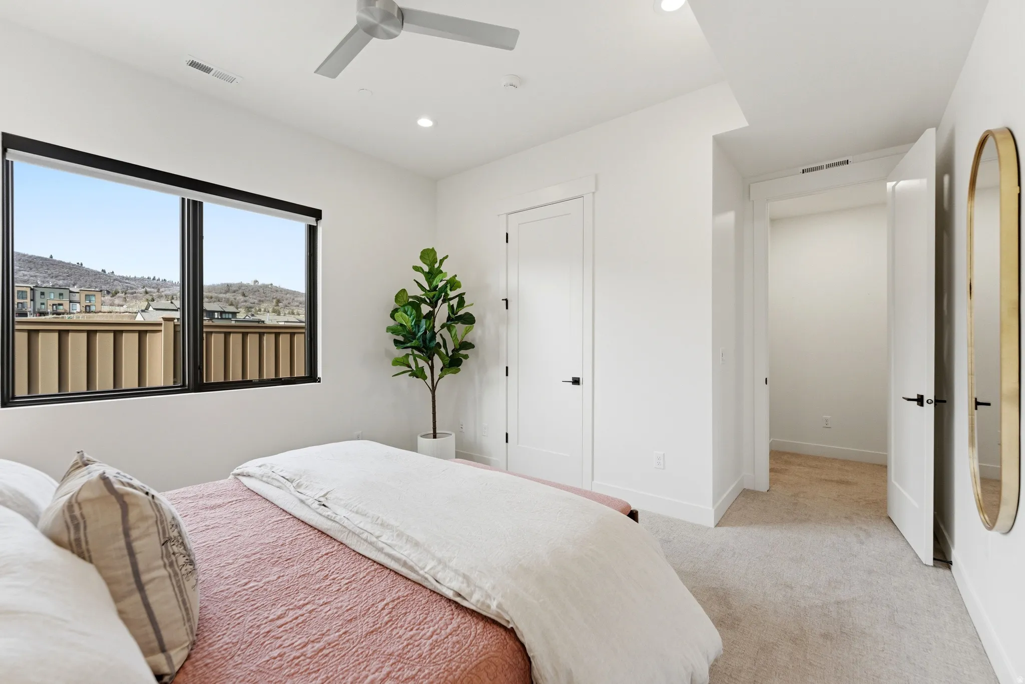 Bedroom with light colored carpet, ceiling fan, and recessed lighting