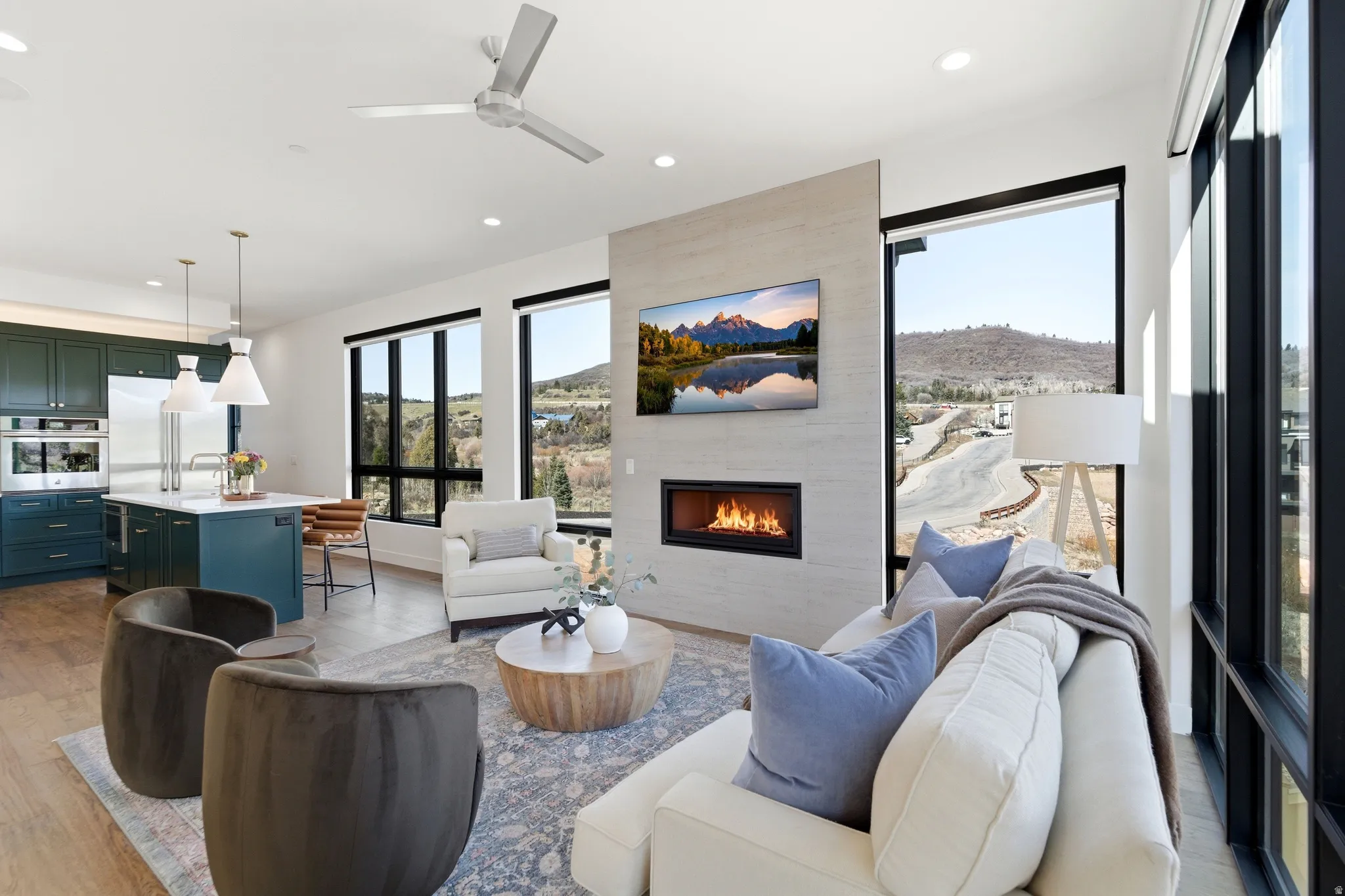 Living room featuring light wood-style floors, a ceiling fan, recessed lighting, and a tiled fireplace