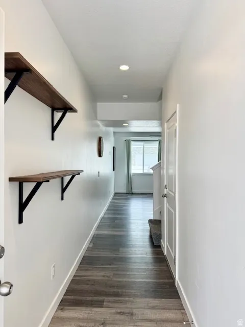 Hall with dark wood-style flooring and recessed lighting