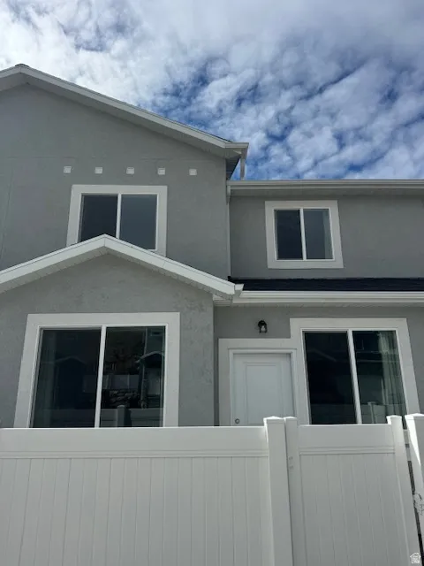 View of front of home with a fenced front yard, stucco siding, and a gate