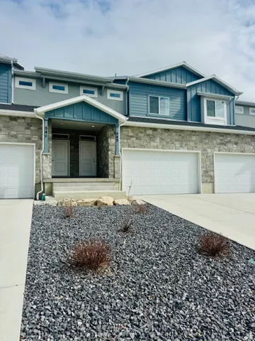 Craftsman inspired home featuring stone siding, board and batten siding, concrete driveway, and an attached garage