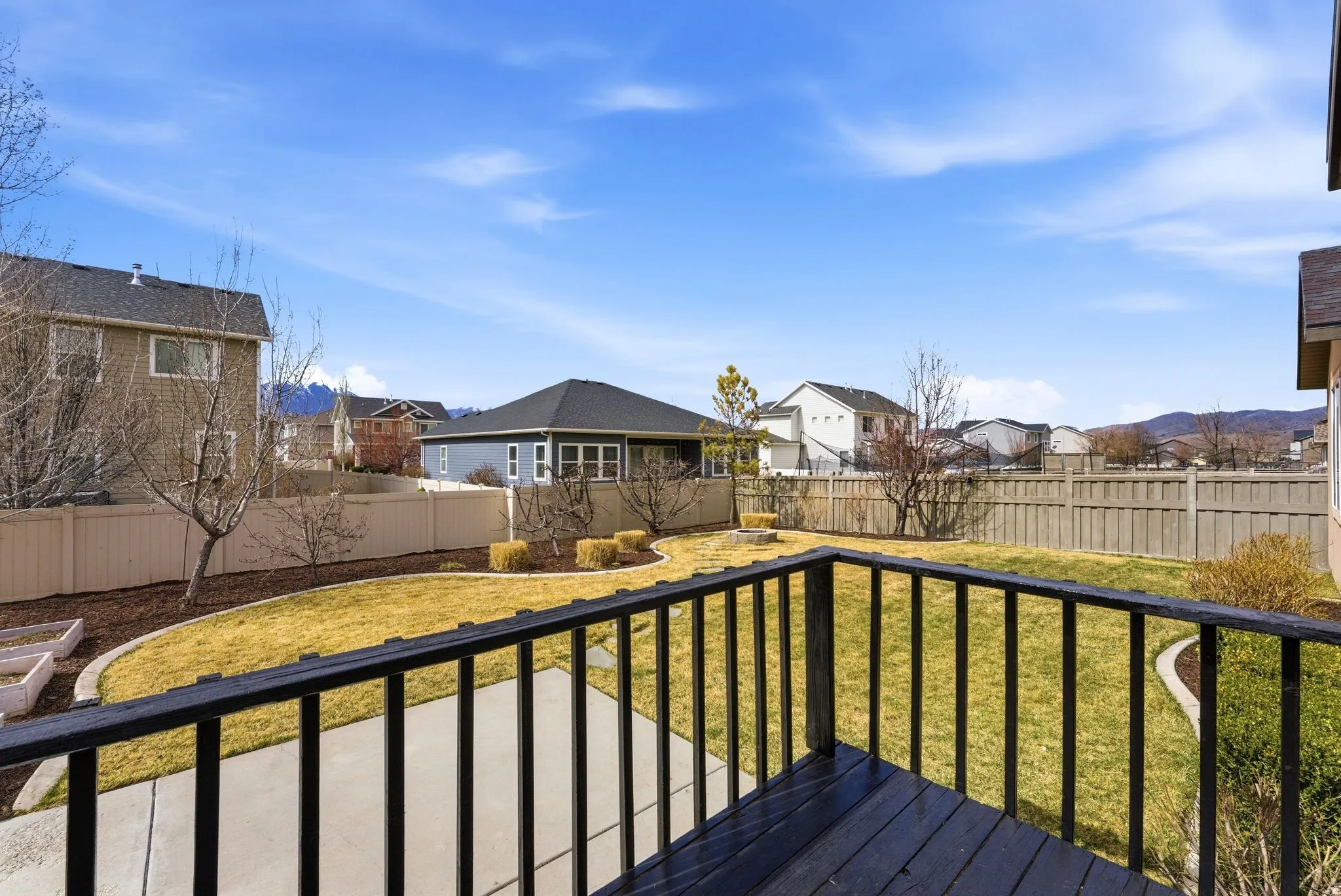 Wooden terrace with a residential view and a fenced backyard