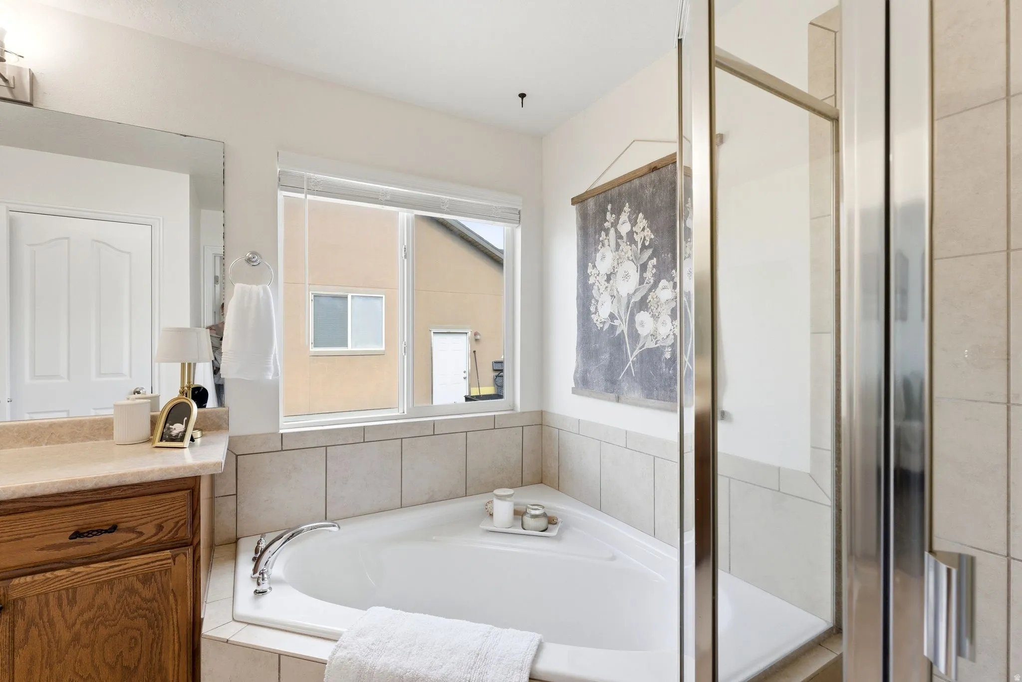 Bathroom featuring a bath, a shower stall, and vanity