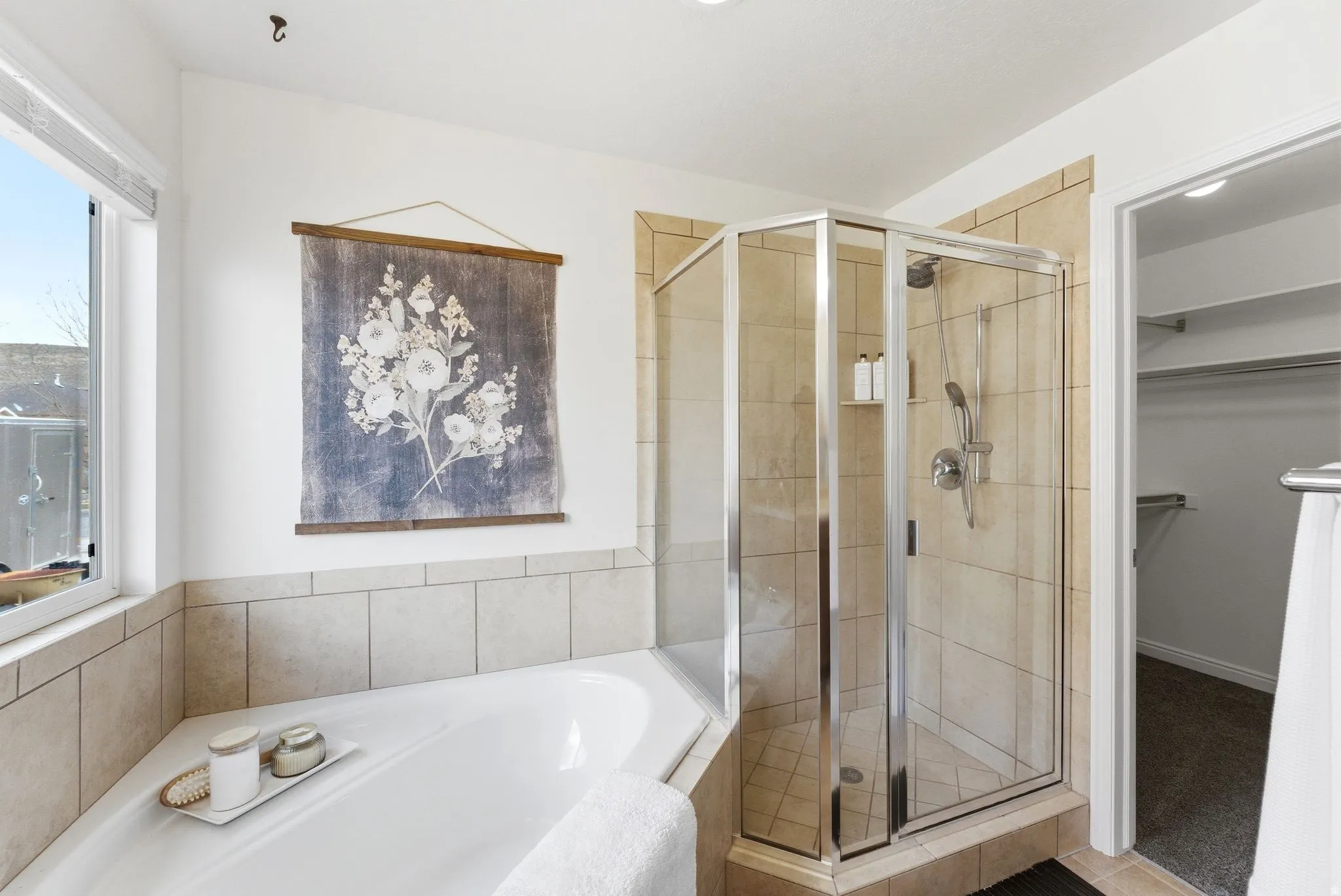 Bathroom featuring a walk in closet, a shower stall, and a garden tub