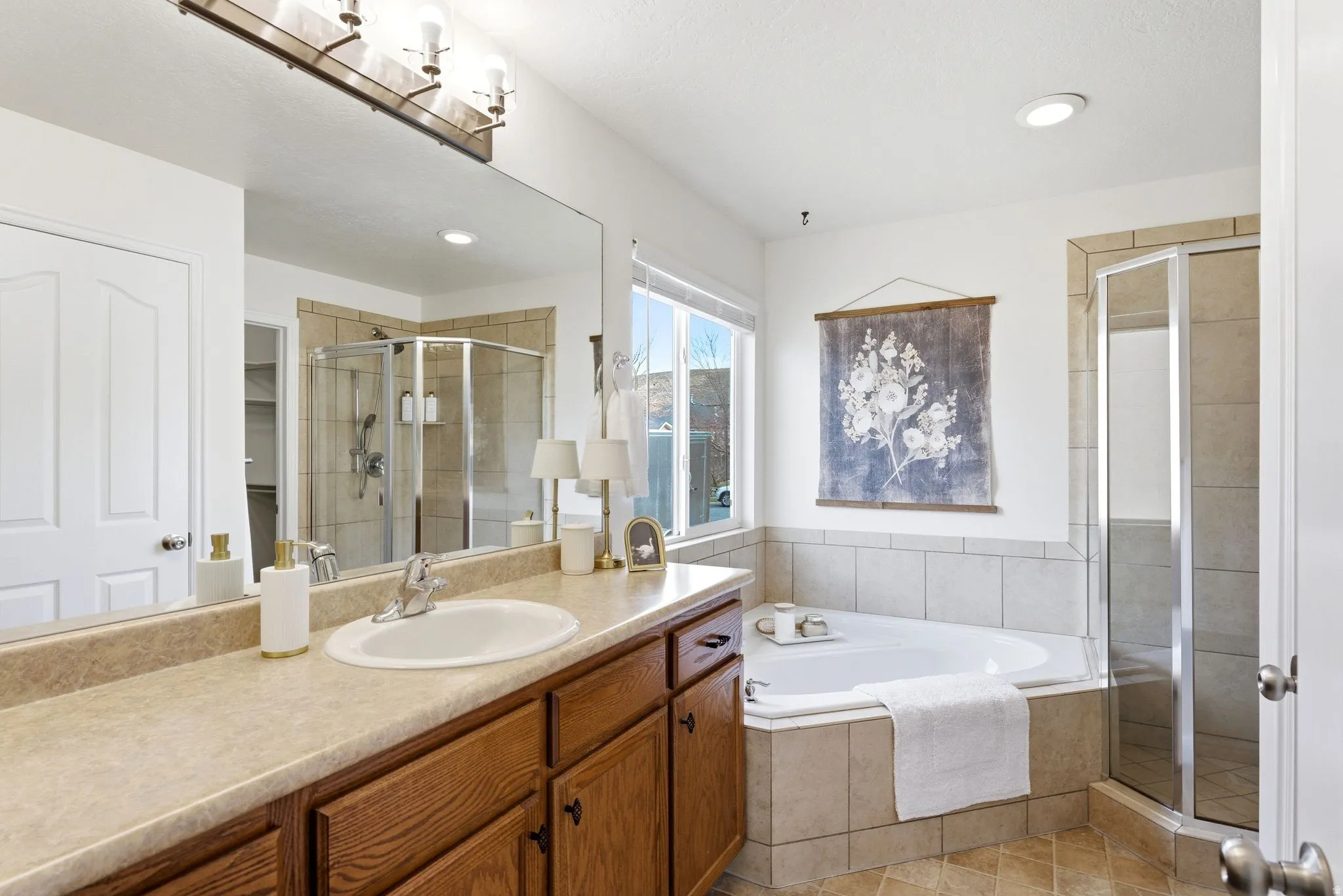 Full bath with a stall shower, vanity, a garden tub, light tile patterned floors, and recessed lighting