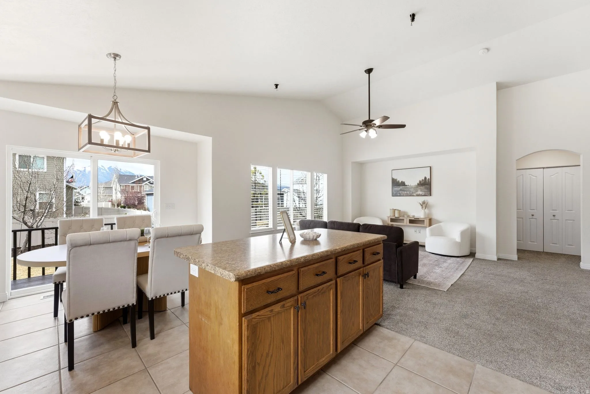 Kitchen with a center island, lofted ceiling, light colored carpet, open floor plan, and arched walkways