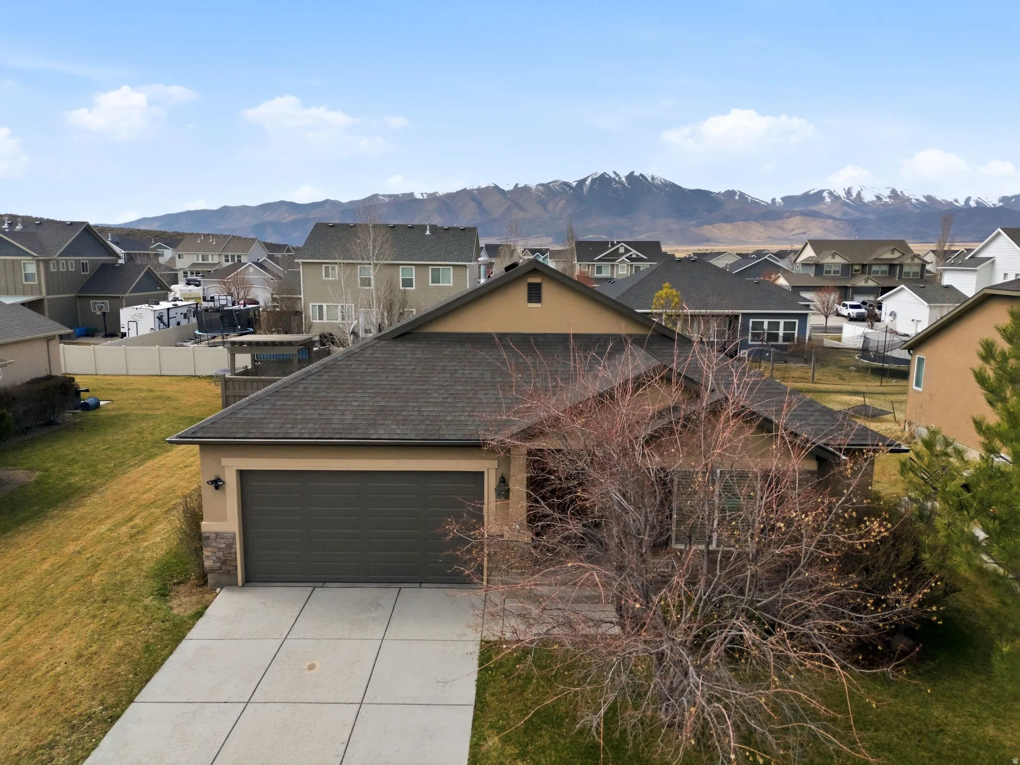 Traditional-style house featuring a residential view, concrete driveway, a garage, and stone siding