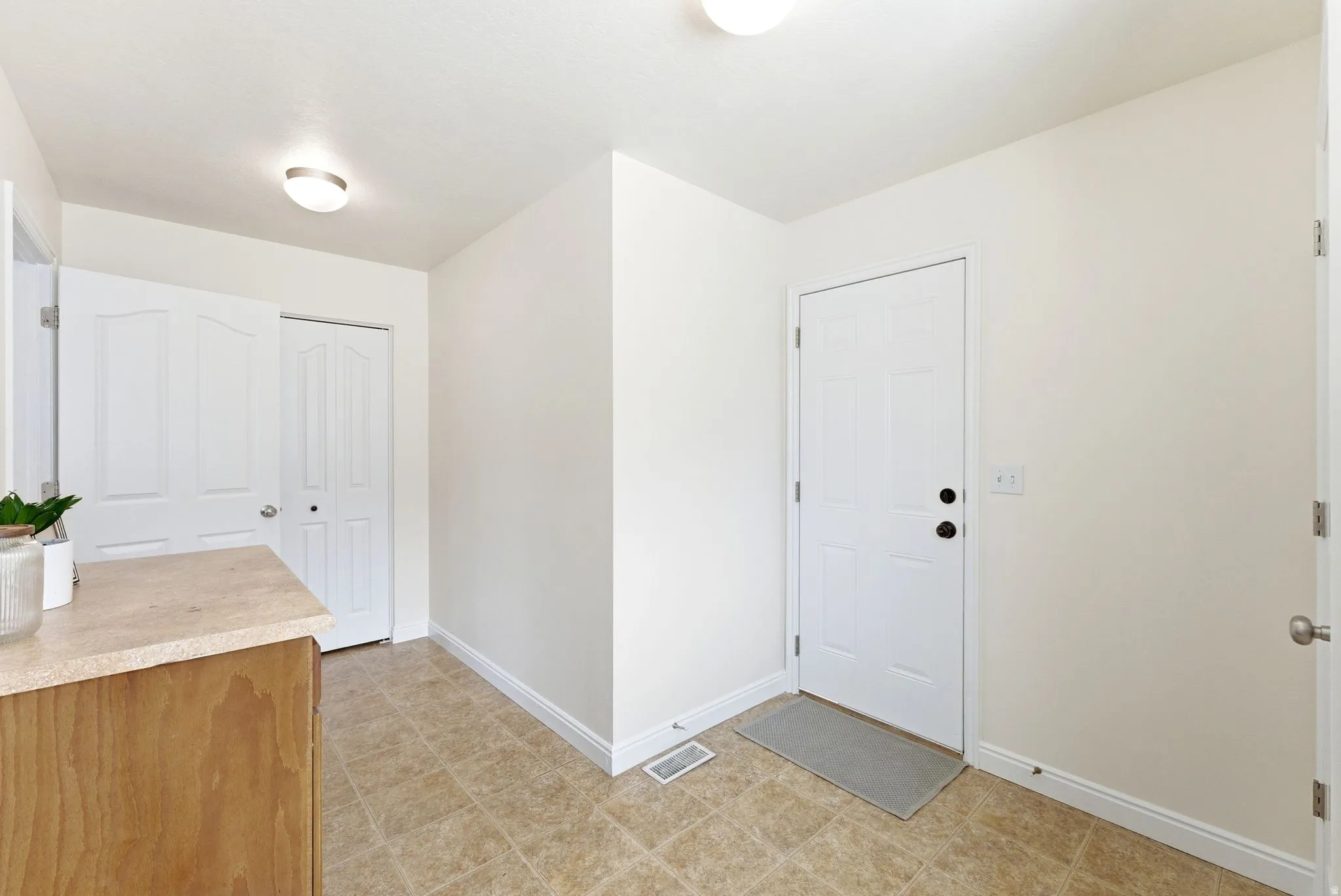 Entryway with baseboards and light flooring