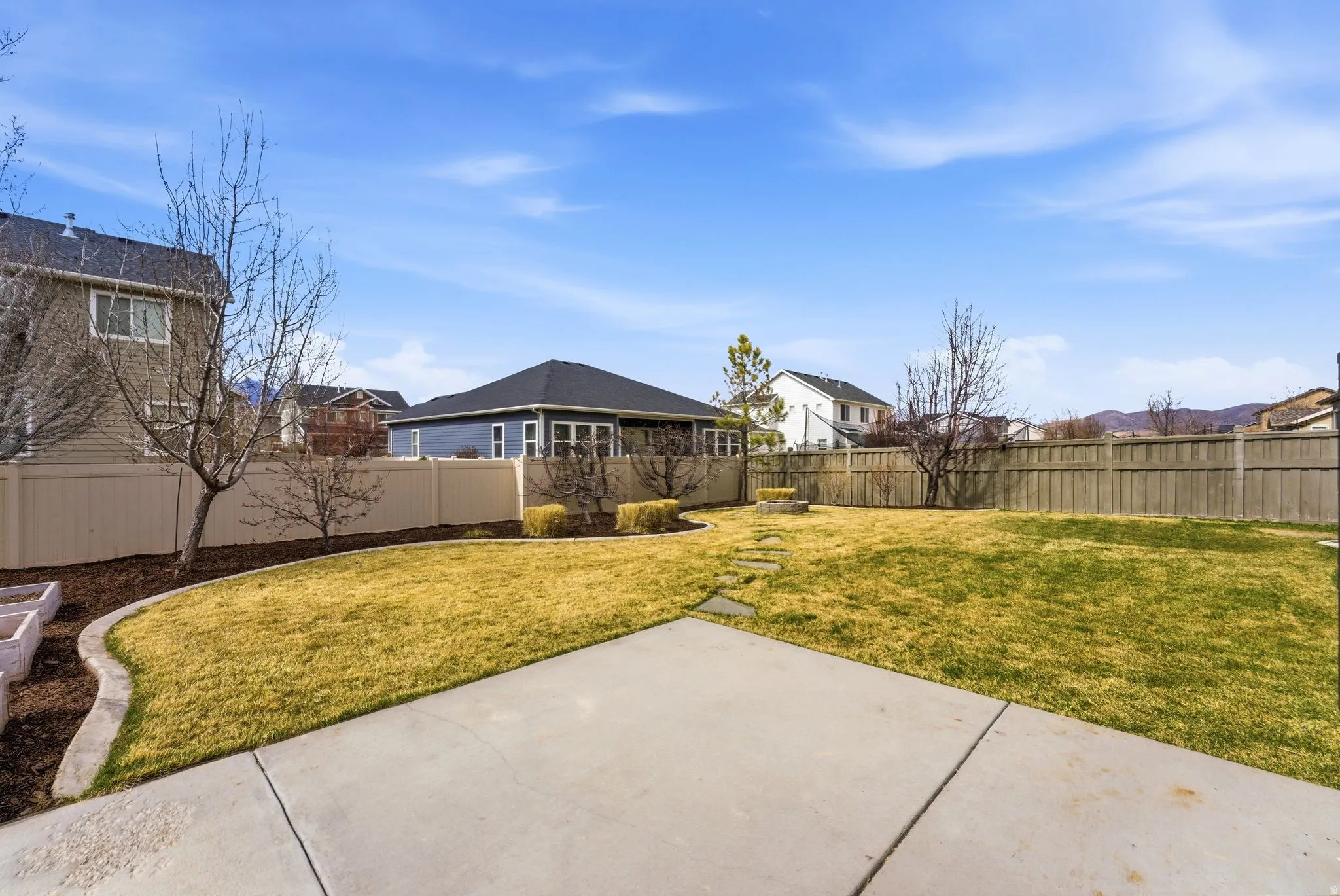 Fenced backyard featuring a patio area and a residential view