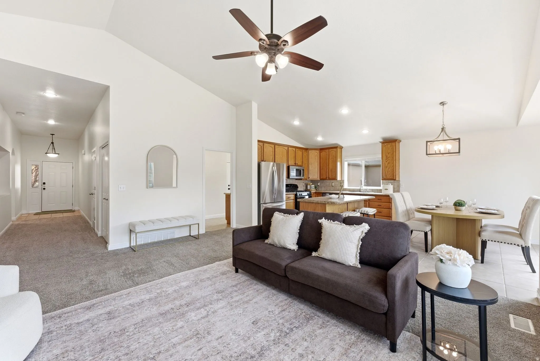 Living room featuring light carpet, vaulted ceiling, recessed lighting, and ceiling fan