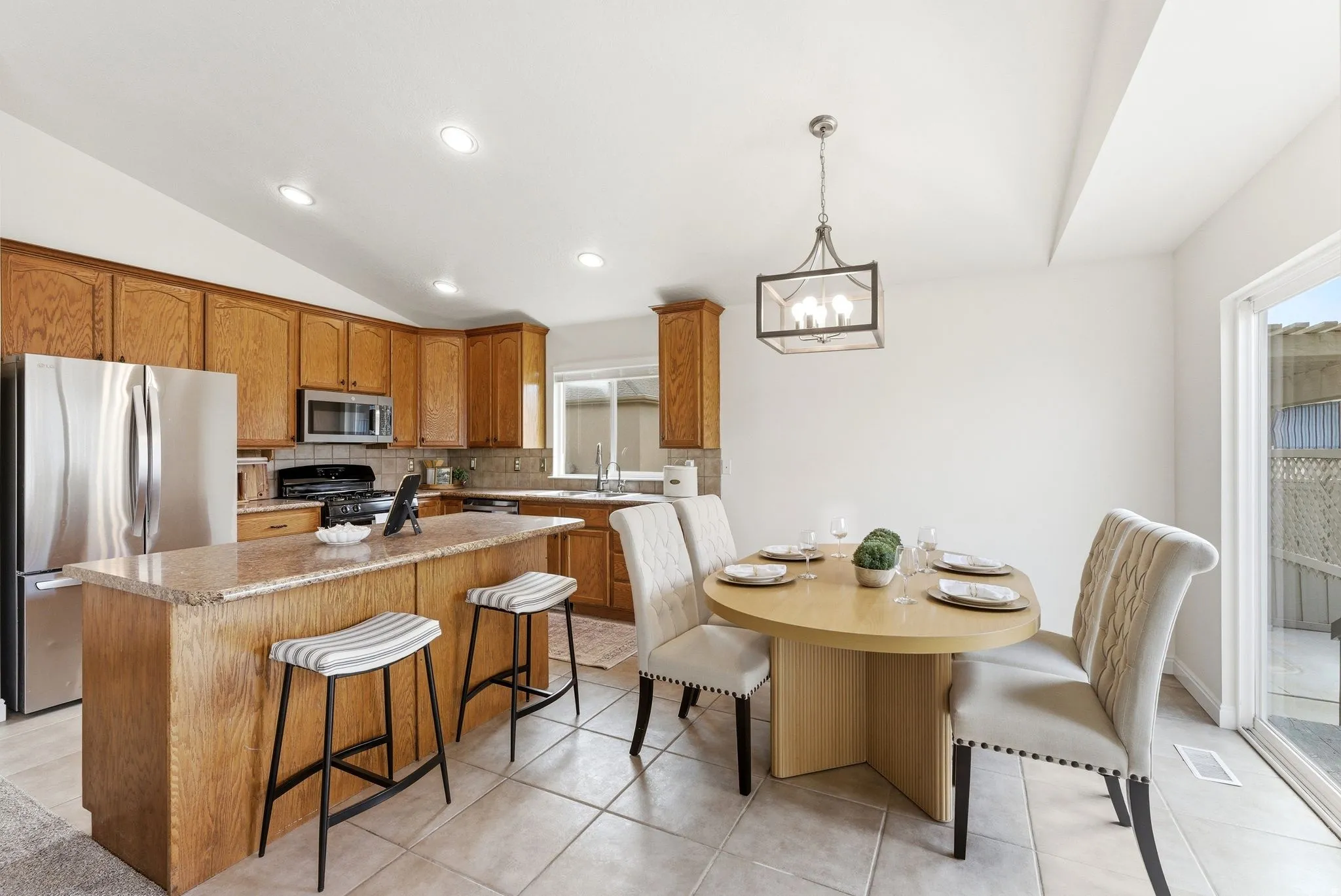 Kitchen with vaulted ceiling, stainless steel appliances, wood finish cabinets, a center island, and a kitchen breakfast bar