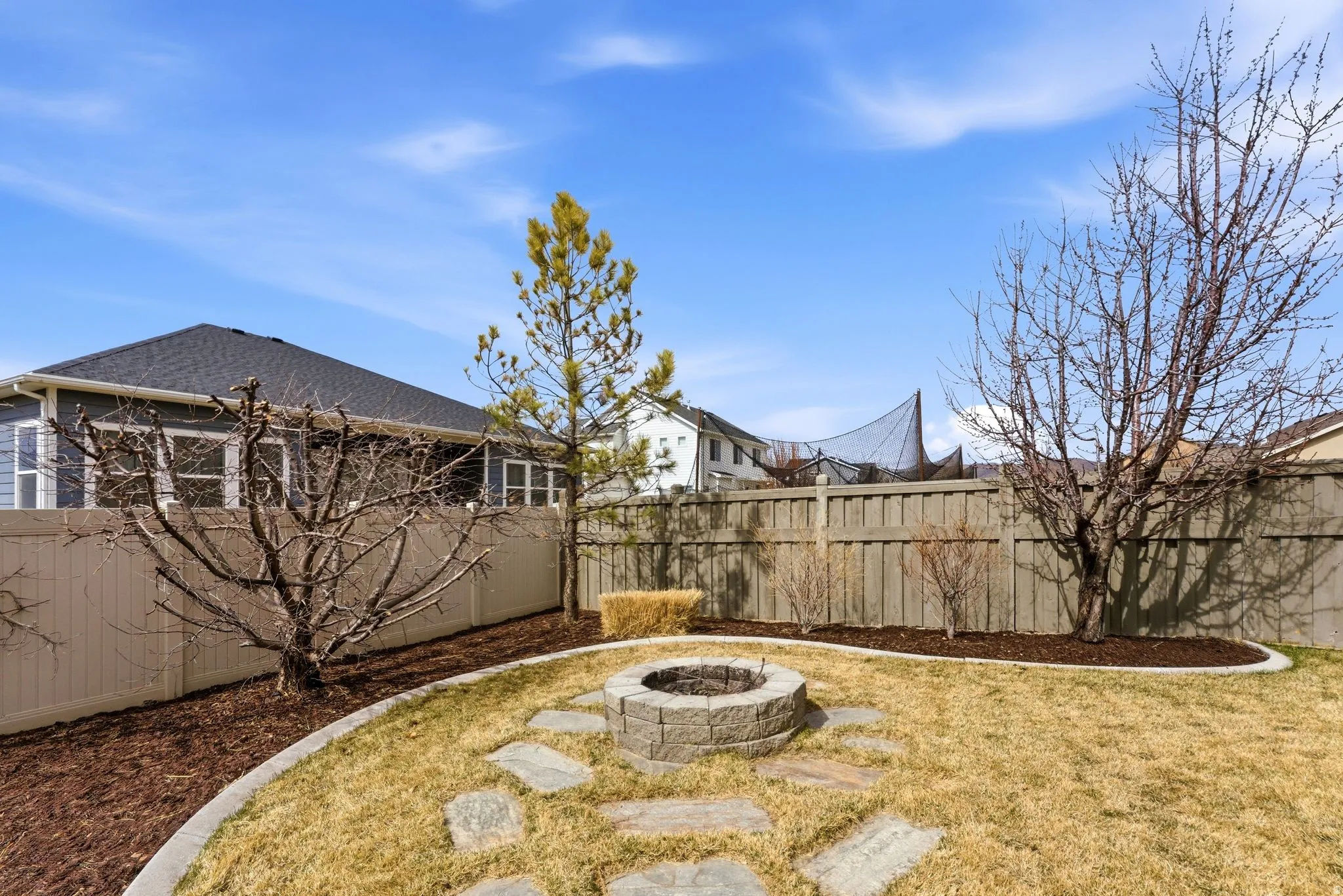 Fenced backyard with a fire pit