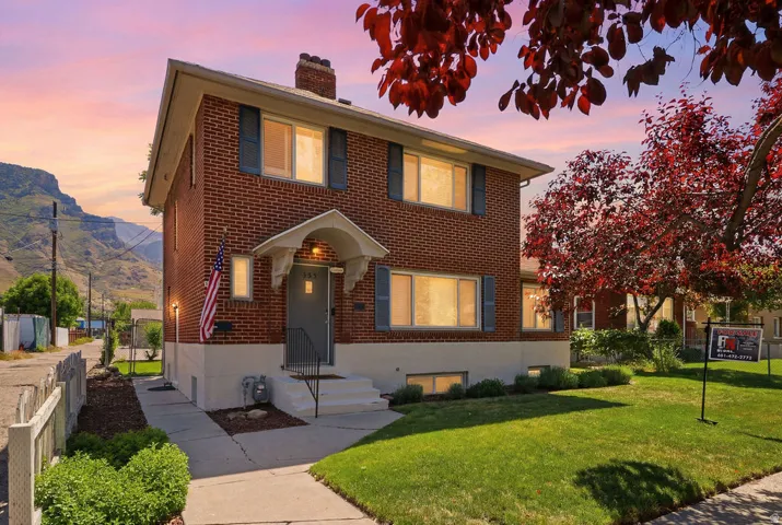Brick two-story residence featuring a covered front entry and a gabled roofline