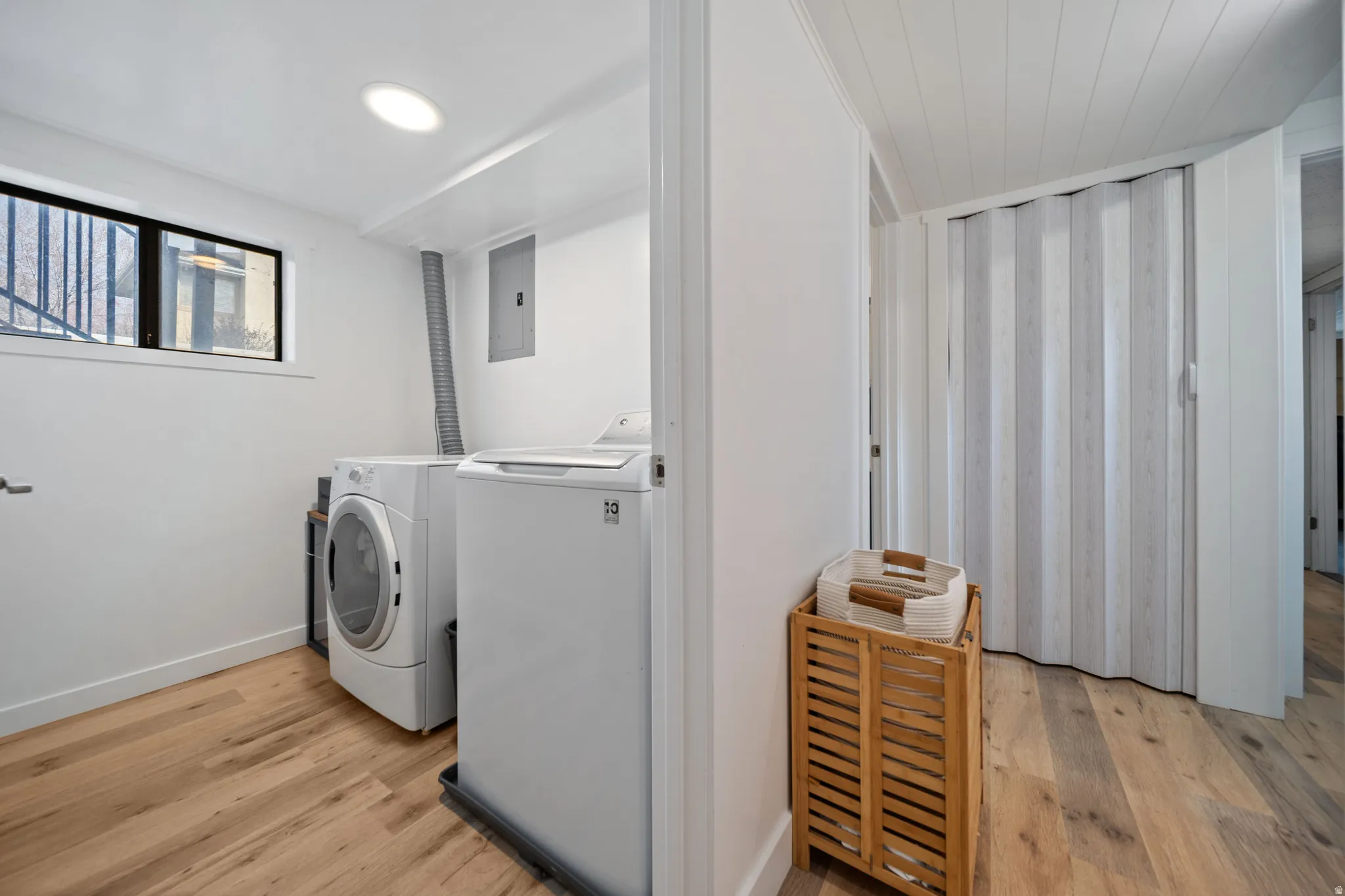 Laundry area featuring light wood finished floors and separate washer and dryer