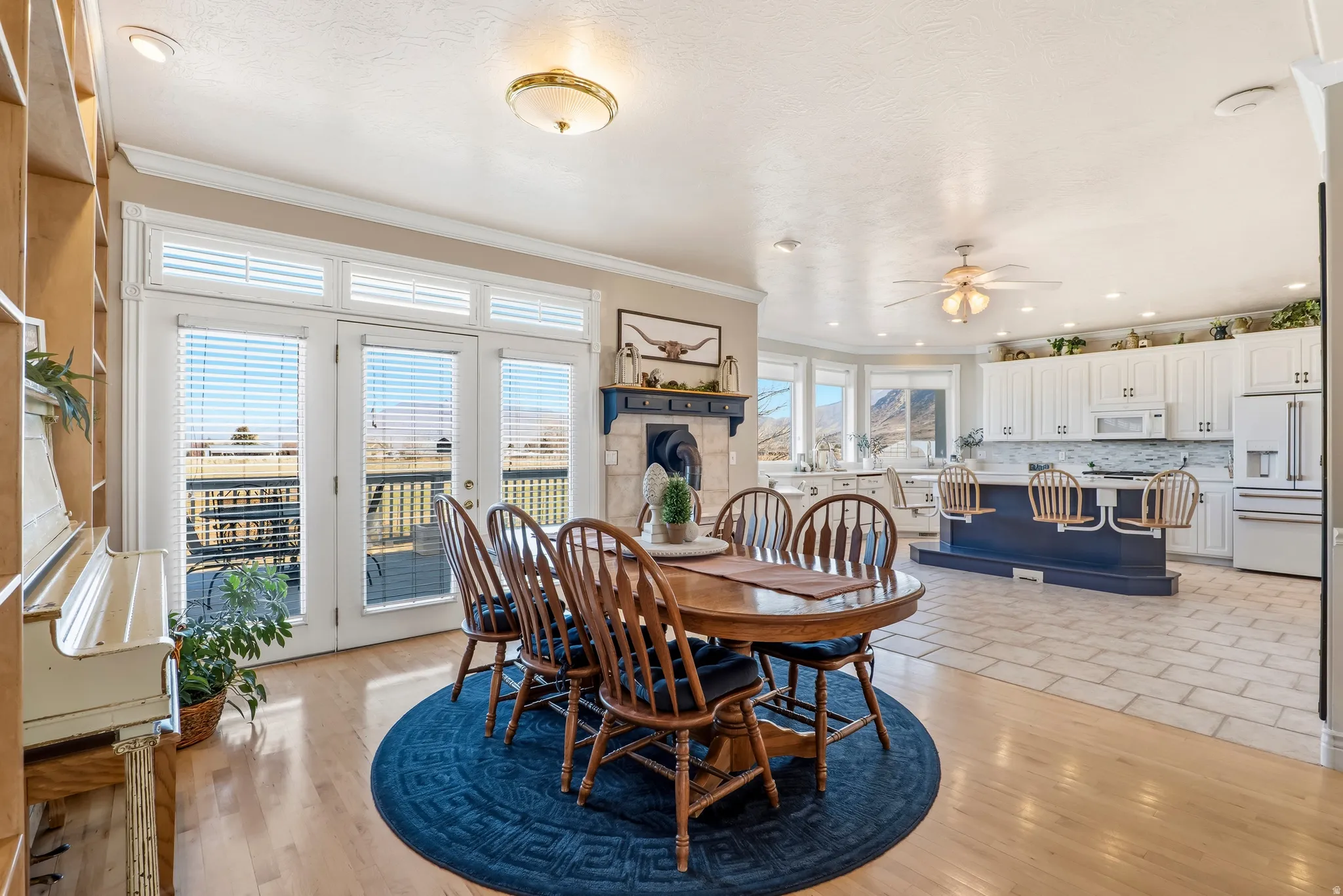 Dining area with ceiling fan, ornamental molding, and light wood-style floors